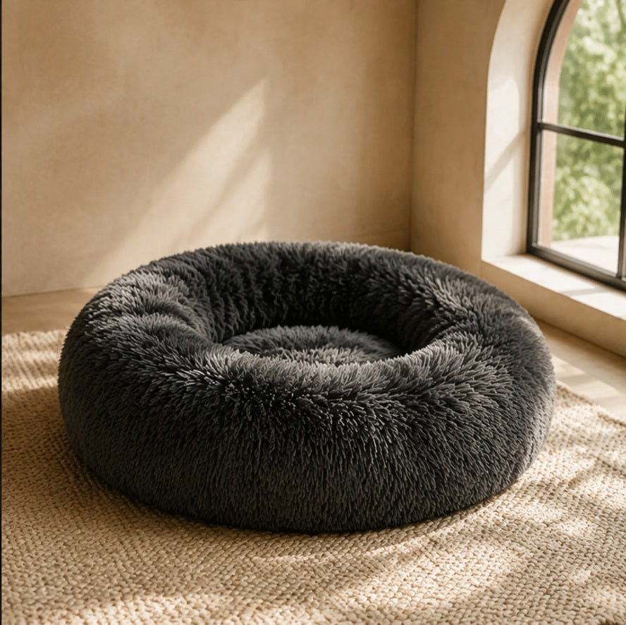 Charcoal plush donut pet bed in a sunlit corner