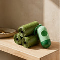 Biodegradable waste bag rolls and dispenser on an oak shelf