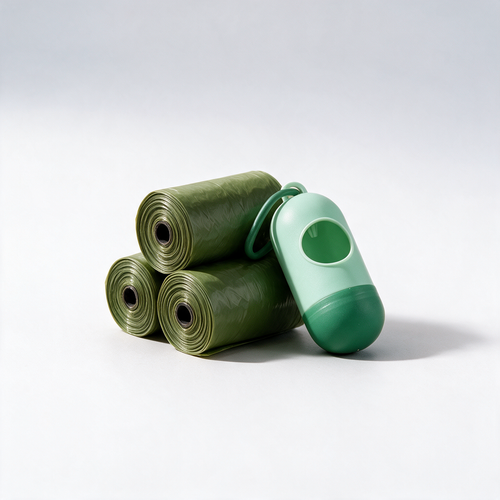 Rolls of waste bags and clip-on dispenser on a white studio background